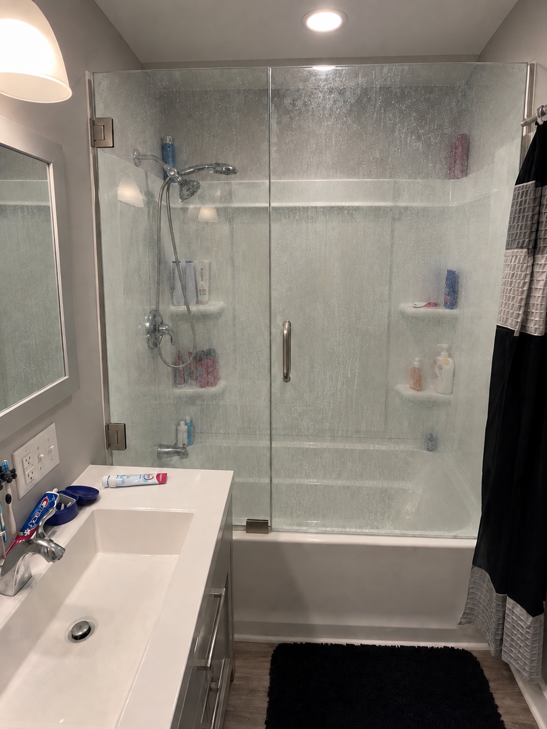 Shower enclosure glass heavily clouded by hard-water mineral build-up